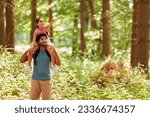 Father Carrying Daughter On Shoulders Hiking Or Walking Through Woodland Countryside
