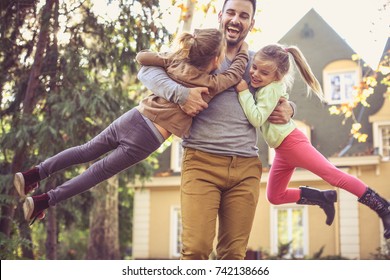 Father carrying daughters around neck.   - Powered by Shutterstock