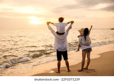Father carrying son and Mother carrying daughter on shoulder walking summer beach, Parents carrying children on shoulders at beach on sunset, Family on holiday summer vacation, Happy family in holiday