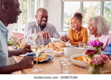 Father Carving As Multi Generation Family Sit Around Table At Home And Enjoy Eating Meal - Powered by Shutterstock