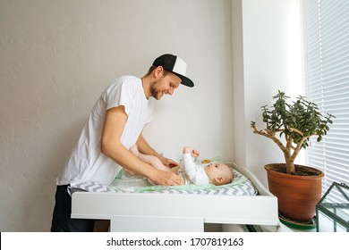 Father change diaper to baby boy on a baby changing table,smile