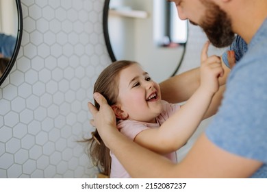 Father Checking His Daughter's Teeth In Bathroom, Morning Routine Concept.