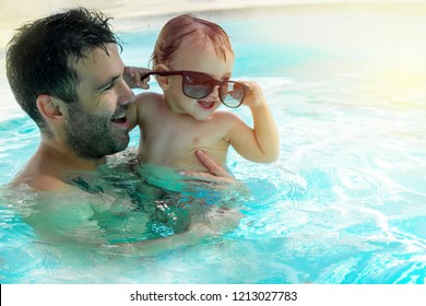 Father And Child Are Having Fun In Swimming Pool. Dad And Son Are  Indoor Pool. Father Teach Son To Swim. Concept Of Kids Sport, Family Summer Vacation. Concept Of Healthy Holiday And Family Activity