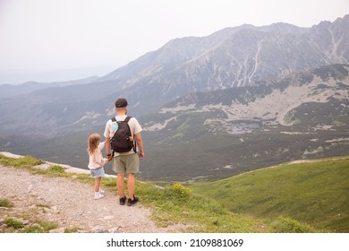 Father And Child Hiking In Scenic Mountains. Dad And Daughter Enjoying The View From The Mountain Top.