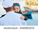 Father, child and marine uniform with hug or sailor captain at ocean for service duty, reunion or embrace. Man, daughter and happiness greeting for travel return or patriotic hero, family or navy