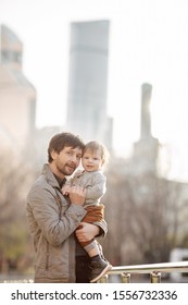 Father and child in the park against the background of skyscrapers