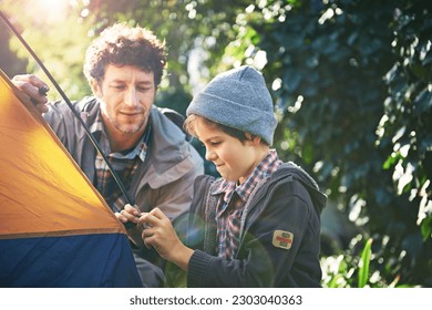 Father, child and set up tent for camping outdoor in nature on vacation while bonding in summer. Dad, boy and preparing campsite, learning and getting ready in forest for travel, education or holiday - Powered by Shutterstock