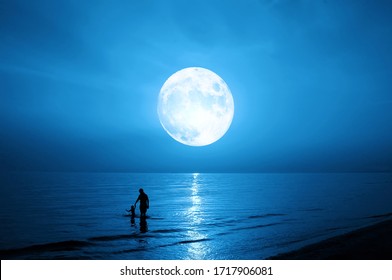 Father And Child Silhouette. Sea And Full Moon