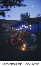 Father With Children Playing Under Their Backyard Tent.