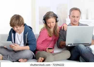 Father And Children Using Electronic Devices At Home