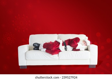 Father Christmas Sleeps On A Couch Against Red Background