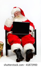 Father Christmas Using Laptop And Thinking