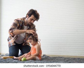 Father Combing Messy Hair For Cute Little Toddler Girl Who Sitting On The Carpet In The Living Room At Home.