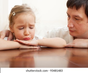 Father comforts a sad child. Problems in the family