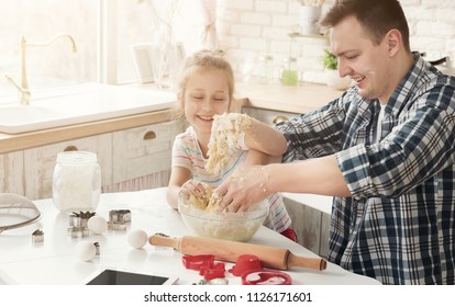 Father Is Cooking Pastry With Daughter First Time In Kitchen. Happy Man And Little Girl Kneading Too Liquid Dough And Laughing, Fail With Recipe, Copy Space