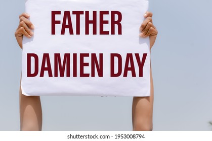 Father Damien Day With Banner In Hand In Sky Background