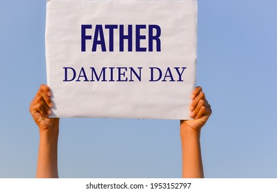 Father Damien Day With Banner In Hand In Sky Background