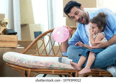 Father and daughter blowing up balloons, having fun together, little girl play balloon with her father in new house at moving day