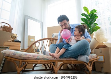 Father and daughter blowing up balloons, having fun together, little girl play balloon with her father in new house at moving day