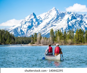 Father And Daughter Canoeing On Jackson Lake In The Grand Teton National Park.