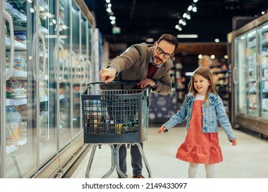 Father and daughter choosing food in grocery store. Young man and little girl standing near fridge with products. Family shopping - Powered by Shutterstock