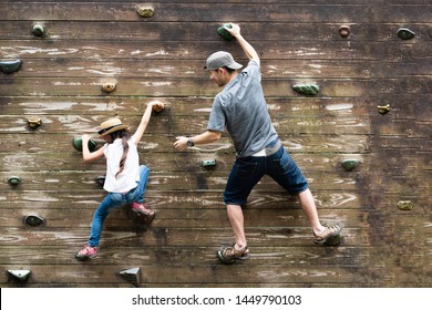 Father and daughter climbing a wall - Powered by Shutterstock