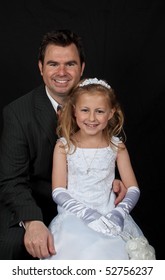 Father And Daughter Close Up Portrait On Black Background. Daddy And Girl First Holy Communion . Father In Suit And Daughter In White Lace Dress With Gloves .