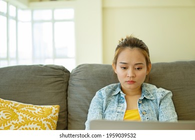Father and daughter concept, young asian girl using laptop at home sitting at the sofa for online class