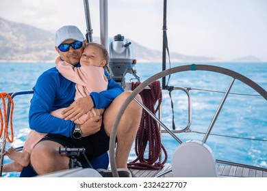 Father and daughter control sailing boat in the sea on boat or yacht. Family, adventure and skipper concept. High quality photo - Powered by Shutterstock