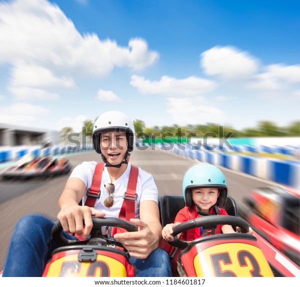 father and\
daughter driving go kart on the\
track