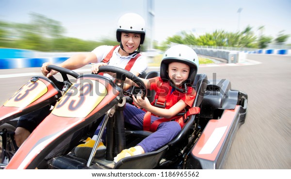father and
daughter driving go kart on the
track
