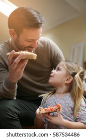 Father And Daughter Eating Pizza.