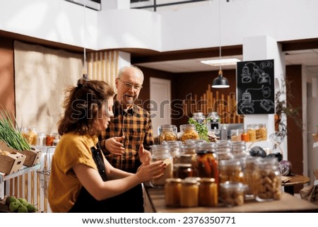 Father and daughter in environmentally responsible zero waste store interested in buying food with high nutritional value. Clients looking for pantry staples in eco friendly reusable packaging