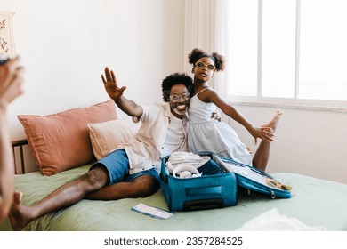 Father and daughter excitedly pose for a photo while packing for a vacation at home. Mature black man and his child having fun as they prepare for a fun-filed family trip together. - Powered by Shutterstock