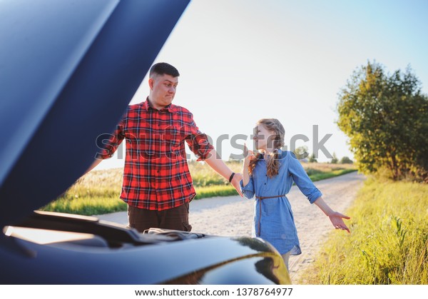 father and daughter fixing problems\
with car during summer road trip. Kid girl helping\
dad.