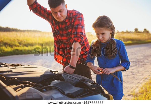 father and daughter fixing problems with car
during summer road trip. Kid helping
dad.