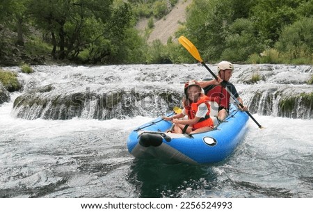 Father and daughter go river rafting in Croatia. Family travel traditions.  Paddling in the river