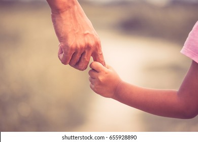 Father and daughter holding hand together in vintage color tone