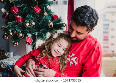 Father And Daughter At Home Wearing Matching Pajamas. Christmas Season