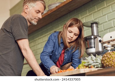 Father and daughter in kitchen preparing fruit and vegetables - Powered by Shutterstock