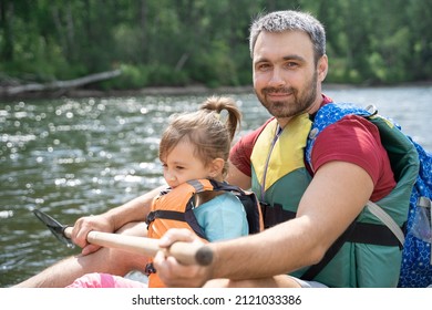 Un père et sa fille dans des gilets de sauvetage descendent en rafting sur une rivière de montagne. Aventures d'été en famille. Rafting sur un fleuve de montagne Iyus, Khakassie