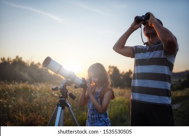 Father and daughter observing the sky with a telescope. - Powered by Shutterstock