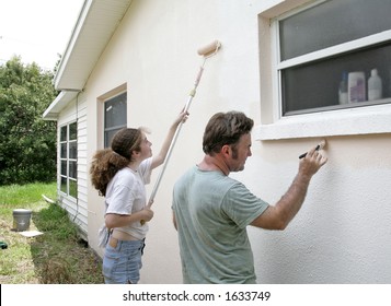 A Father And Daughter Painting Their House Together.