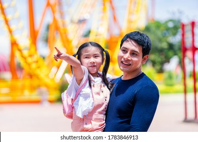 Father And Daughter Play At The Amusement Park. Family In Theme Park.