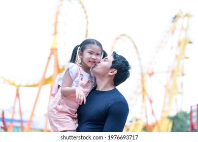 Father And Daughter Play At The Amusement Park. Family In Theme Par K With Roller Coaster Ride