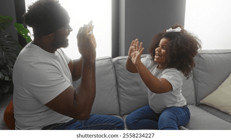 Father and daughter play clapping game in cozy living room depicting family love and bonding. - Powered by Shutterstock