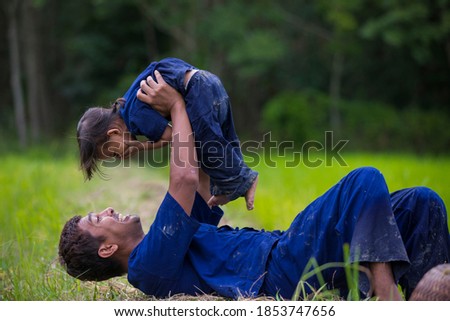 Father and daughter playing around and teasing,Young Thai farmer lifestyle activity in organic farm,Family concept.