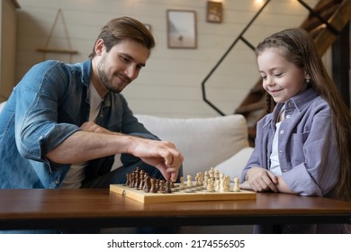 Father and daughter playing chess in the living room at home. - Powered by Shutterstock