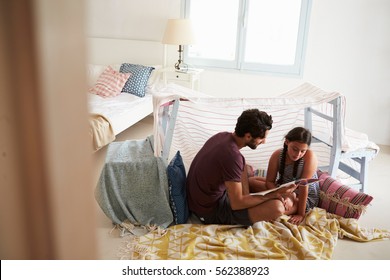 Father And Daughter Playing Indoors In Home Made Den