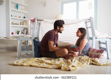 Father And Daughter Playing Indoors In Home Made Den